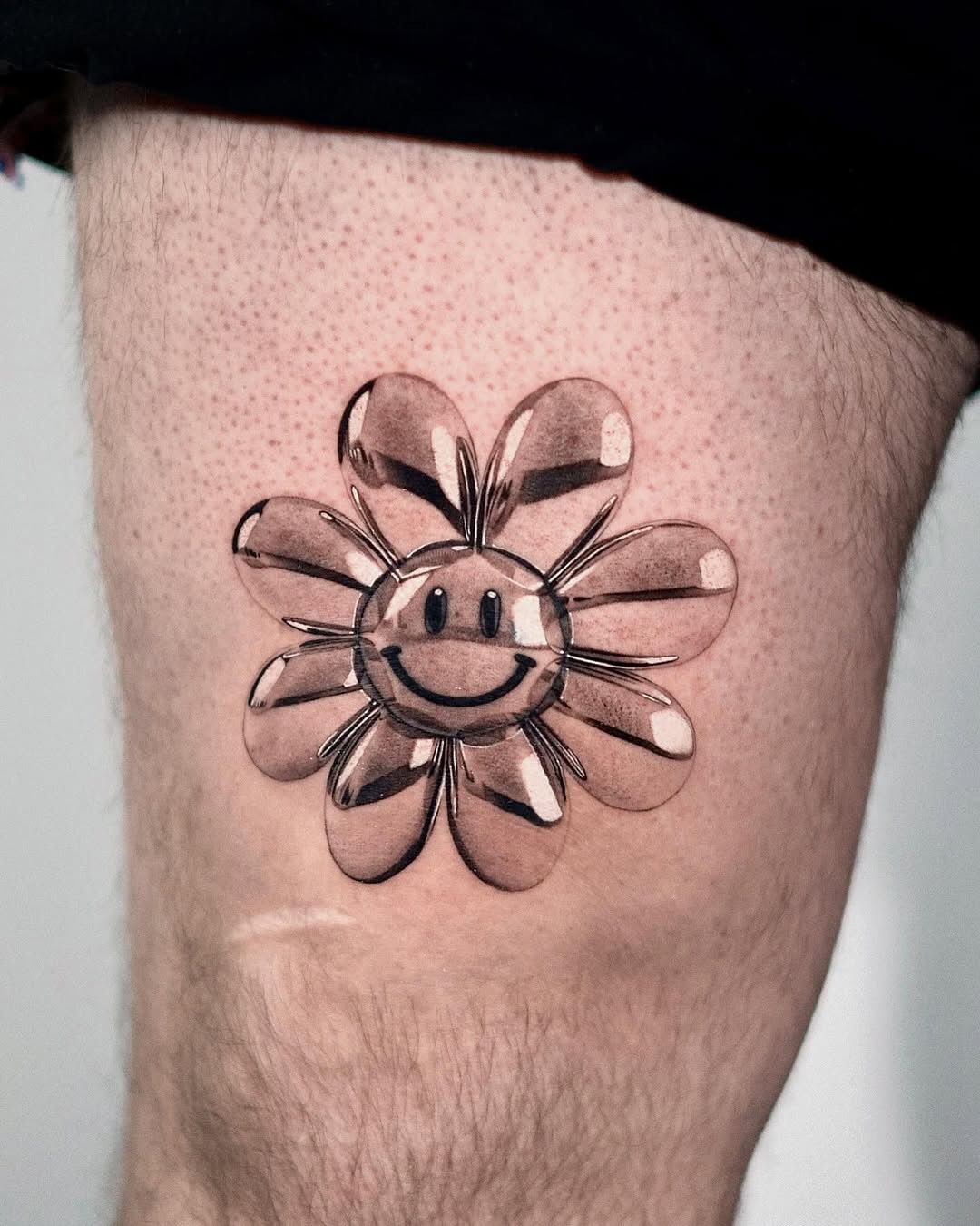 Realistic 3D flower-shaped smiley face tattoo on thigh