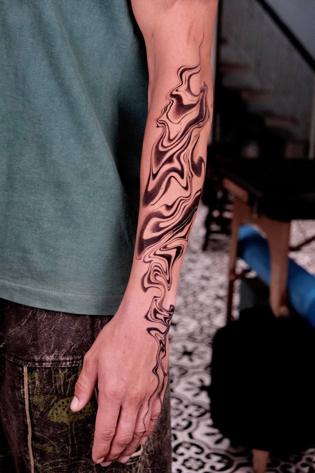 Abstract black liquid marble swirl tattoo covering forearm and hand