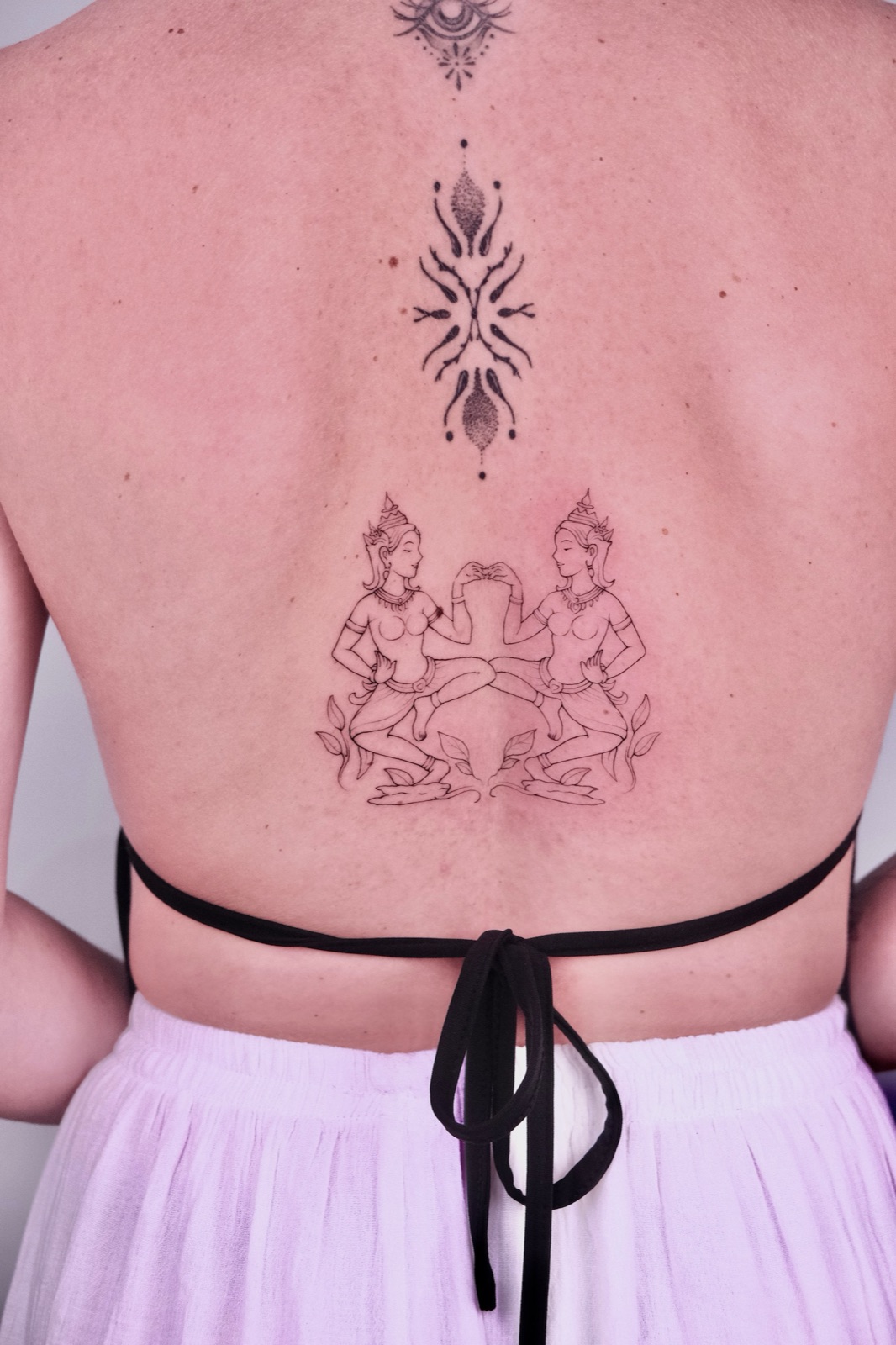 Hình xăm fine-line các vũ nữ Apsara trang trí trên lưng và cột sống