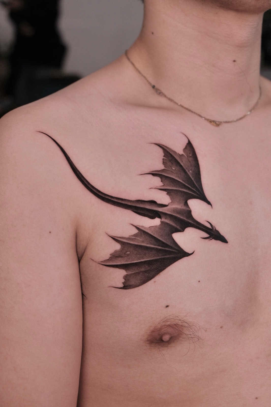 Blackwork dragon tattoo spanning the full chest