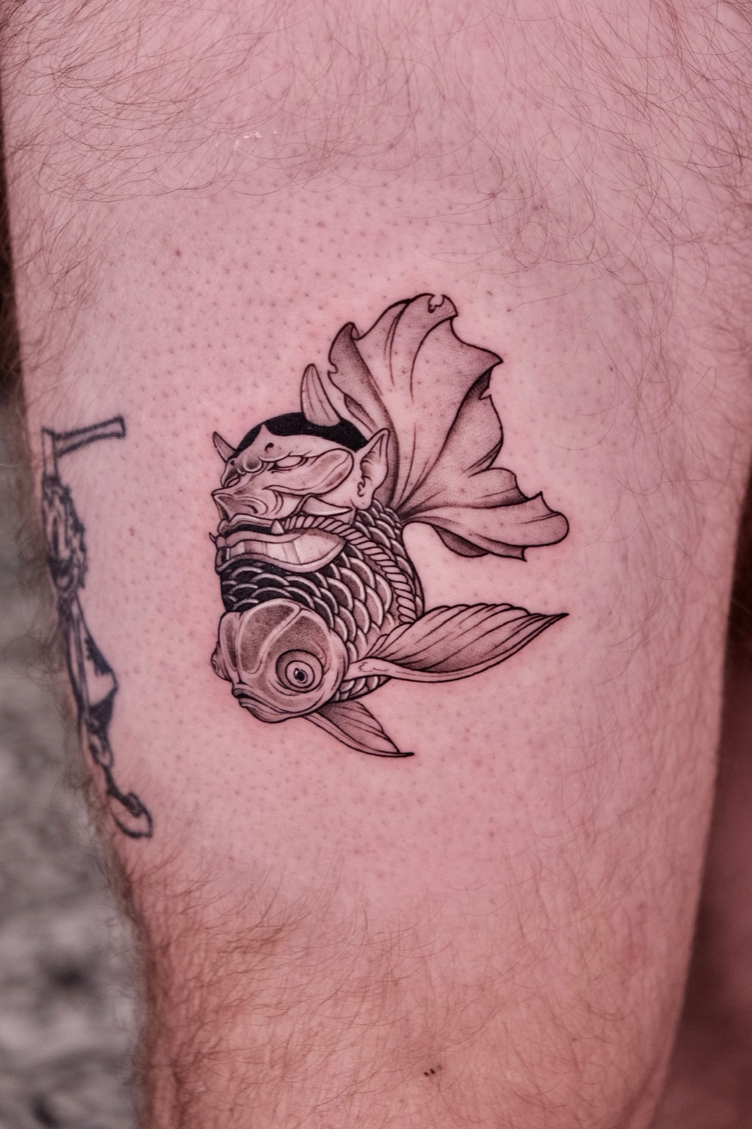 Oni-style dragon-headed koi fish tattoo on thigh with color shading