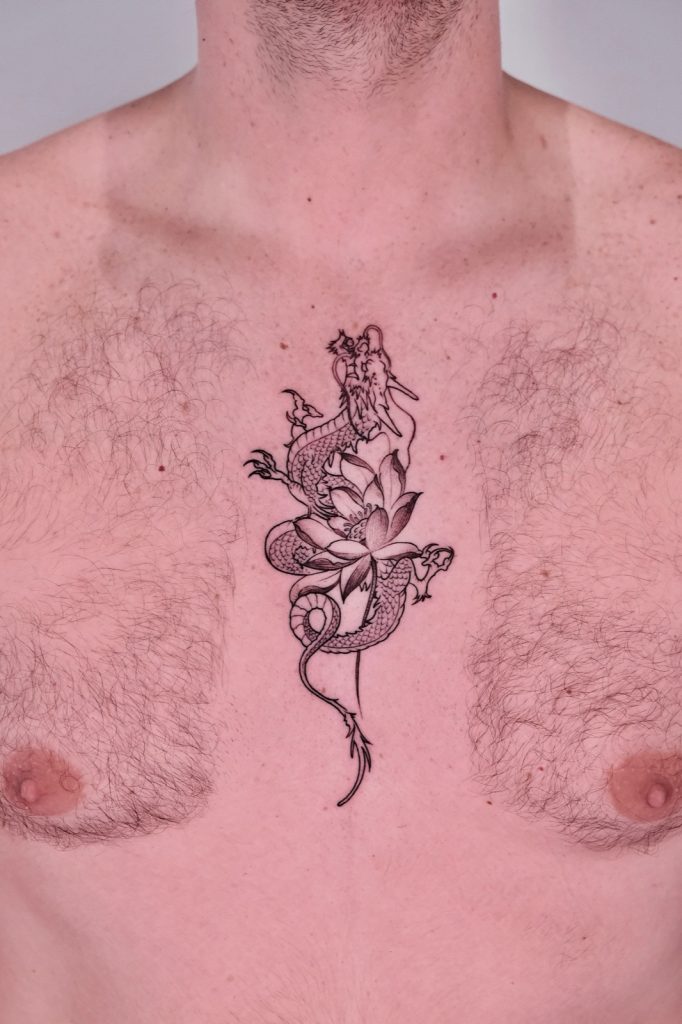 Chinese dragon coiled around a lotus flower tattoo on chest