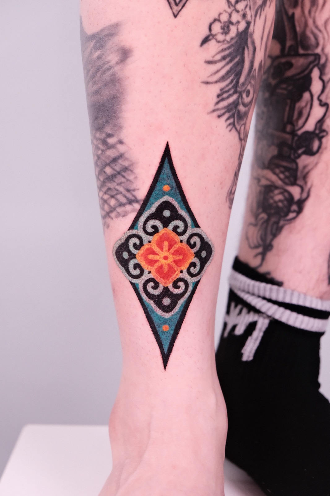 Geometric diamond mandala tattoo on the forearm, an example of a larger, more detailed piece
