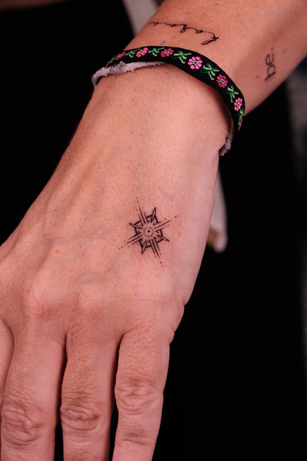 Geometric star compass tattoo on the back of the hand