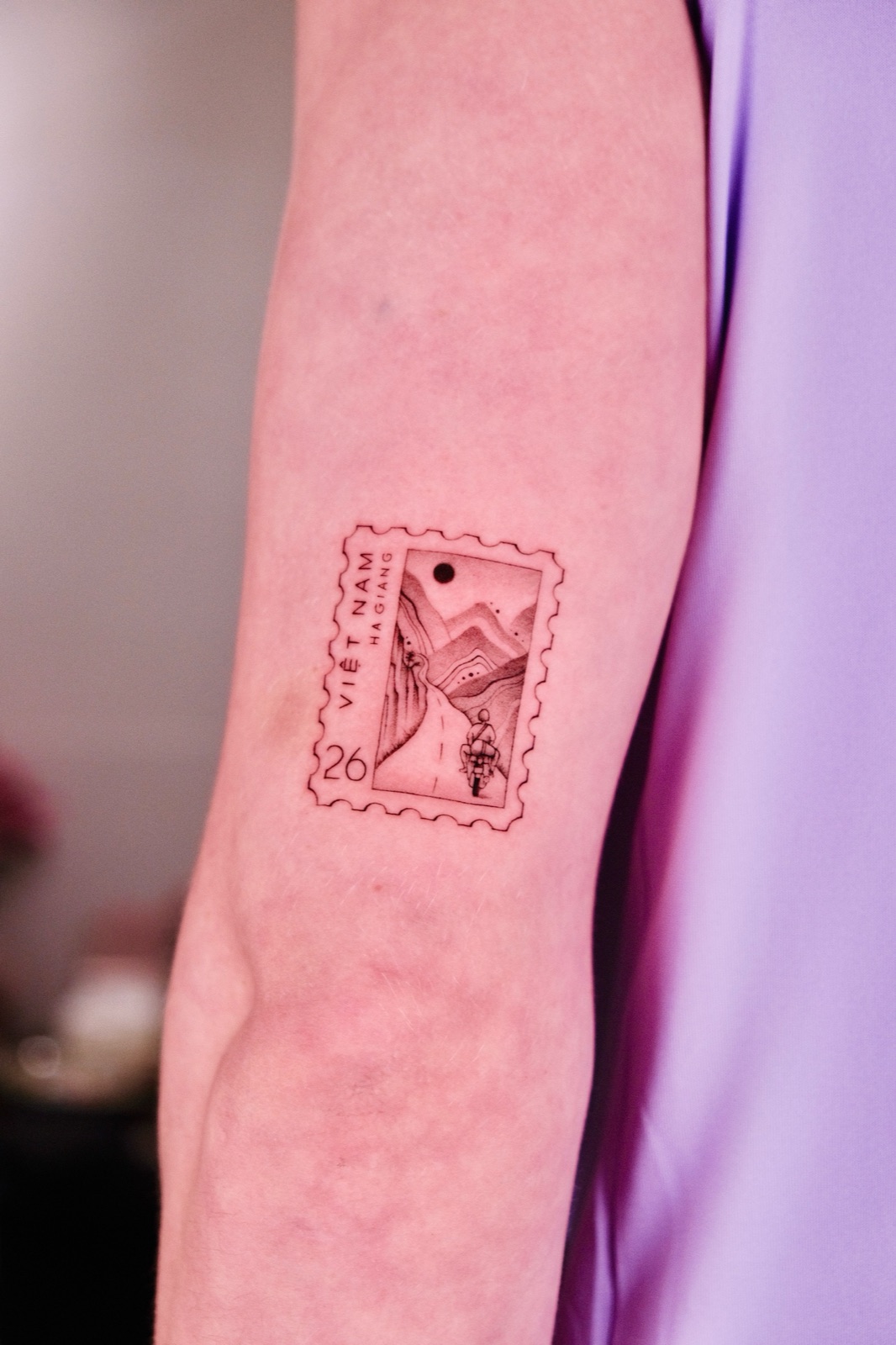 Vietnam Ha Giang postage stamp tattoo of a motorbike on a mountain pass, forearm