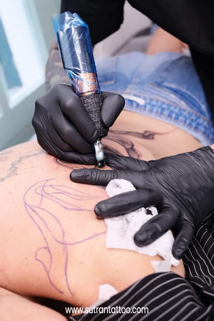Sterile single-use needle and fresh ink caps prepared before a tattoo session