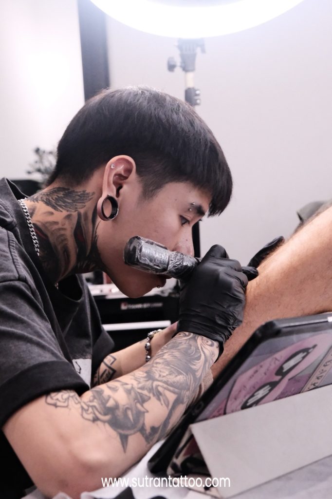 Tattoo artist working on fine linework at a studio in District 1 Ho Chi Minh City