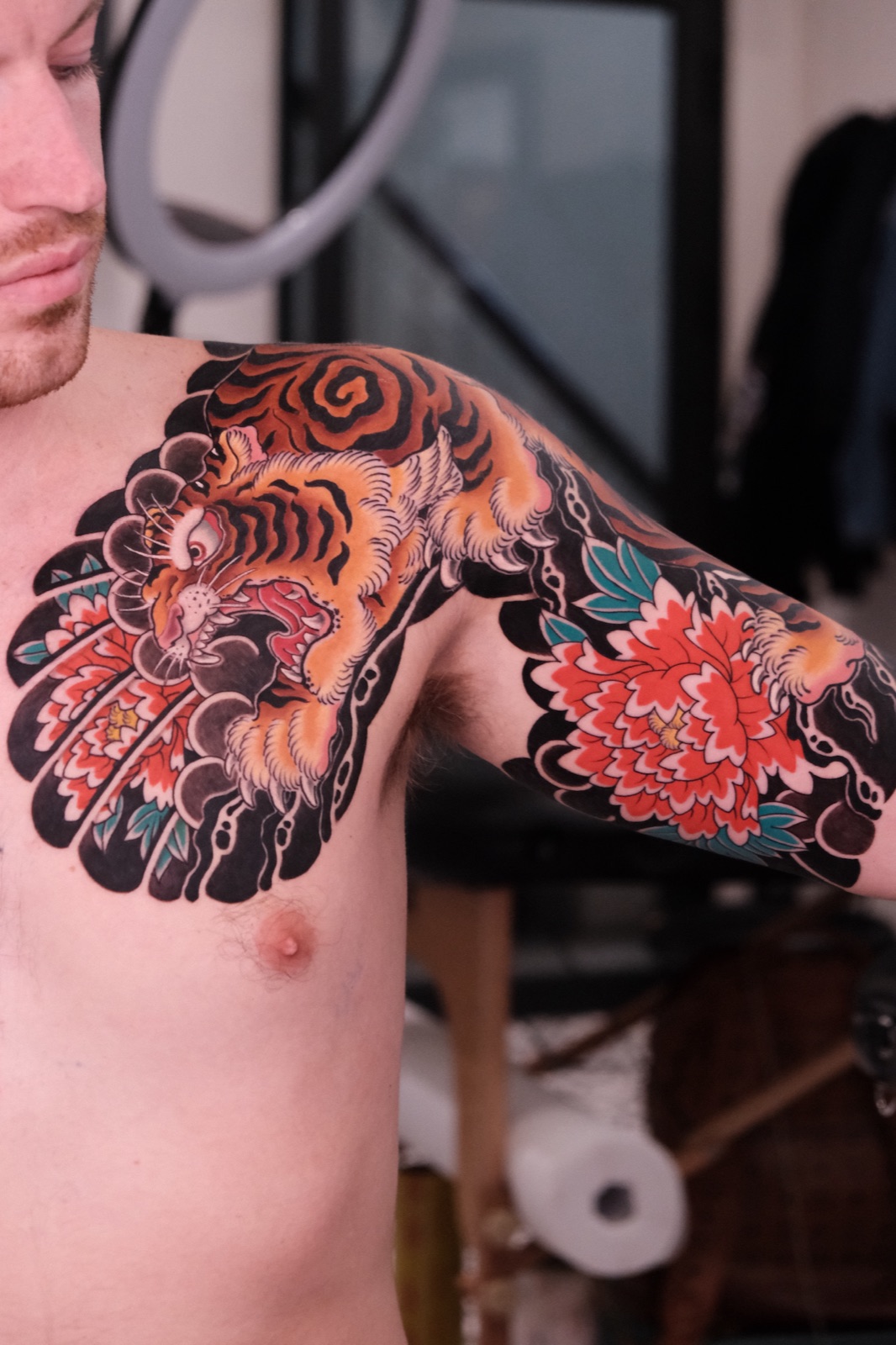 Full color Japanese traditional tiger tattoo with peony flowers across chest and shoulder