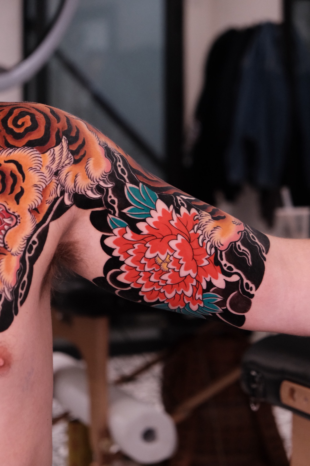 Japanese traditional style sleeve tattoo combining a tiger with peony flowers