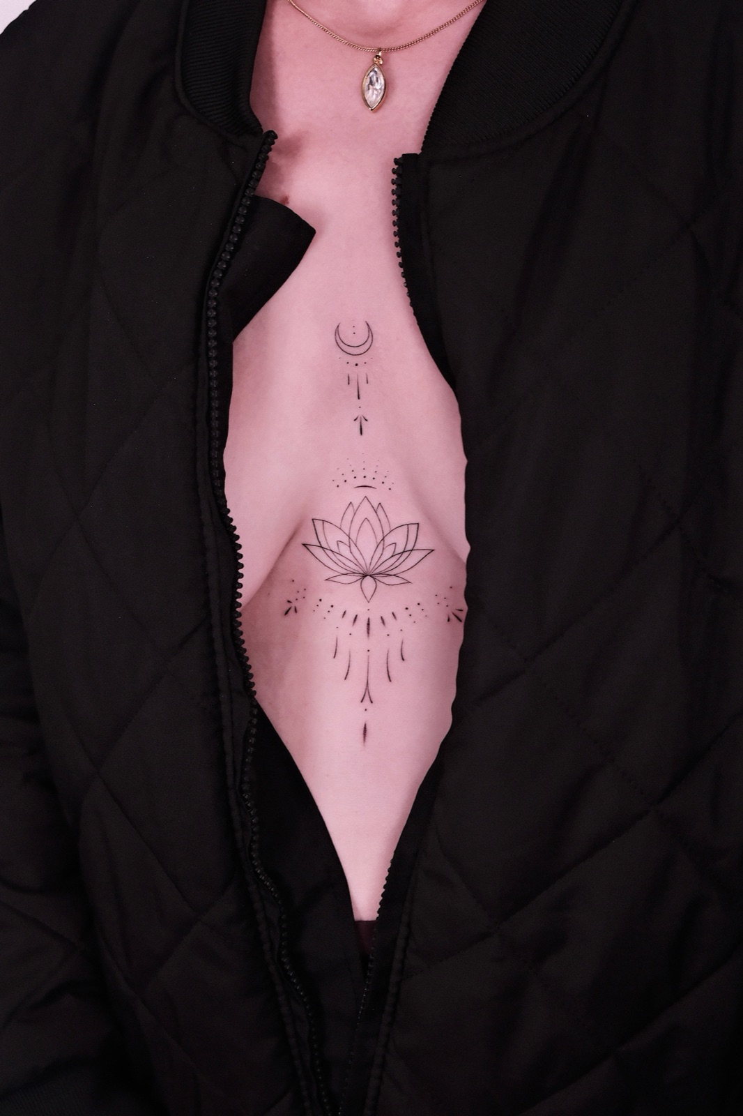 Minimalist crescent moon and lotus flower fine line tattoo on the chest
