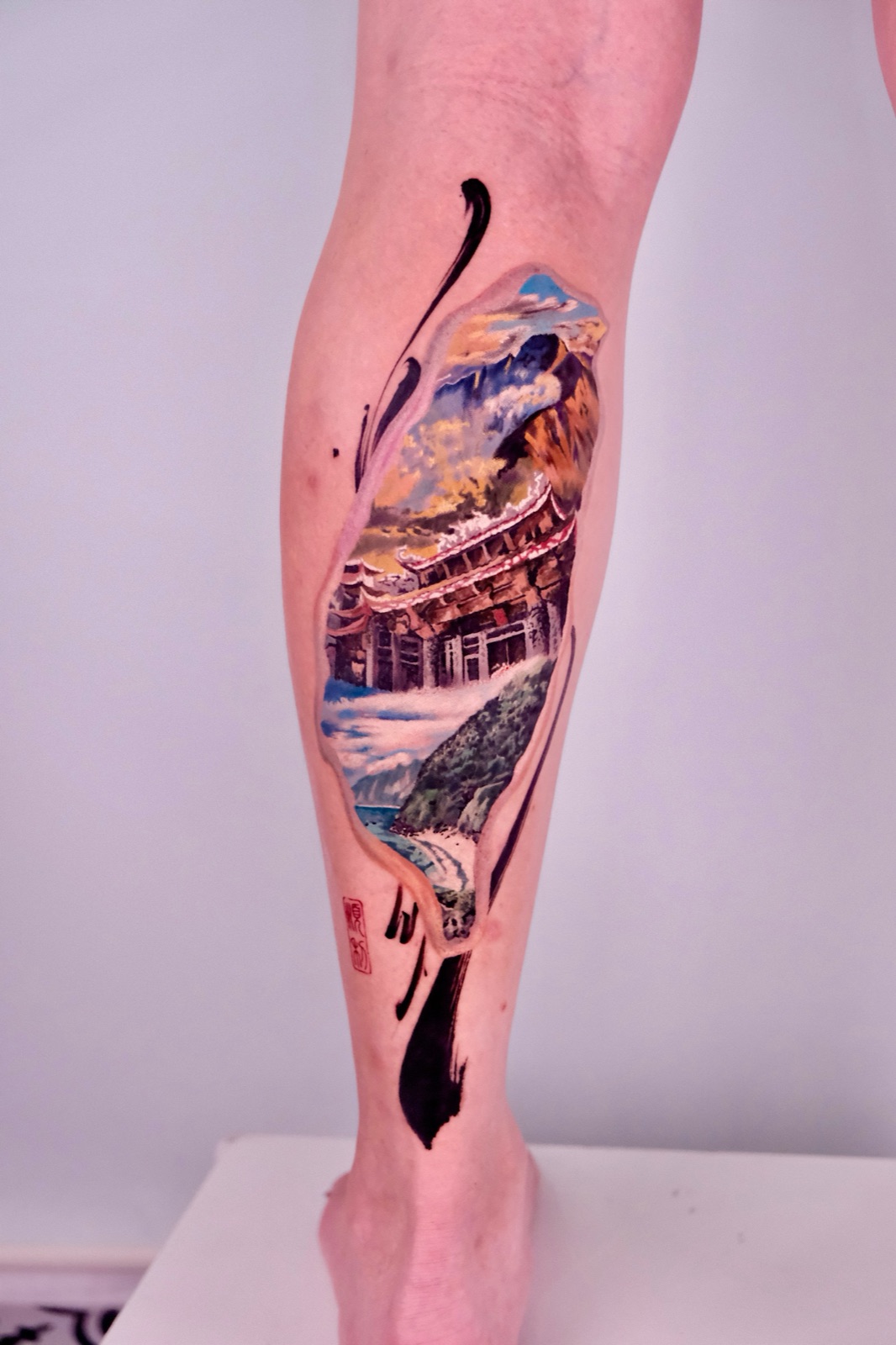 Mountain and temple landscape tattoo on the calf