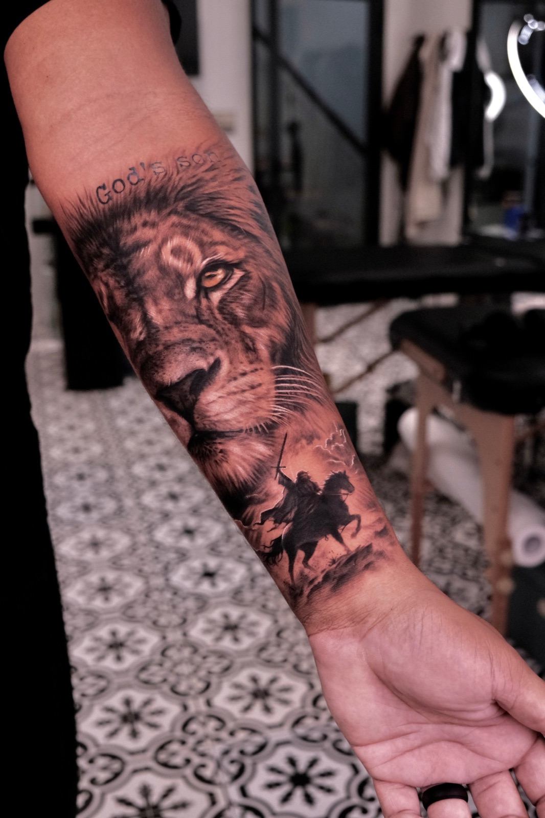 Realistic lion portrait tattoo on a forearm sleeve