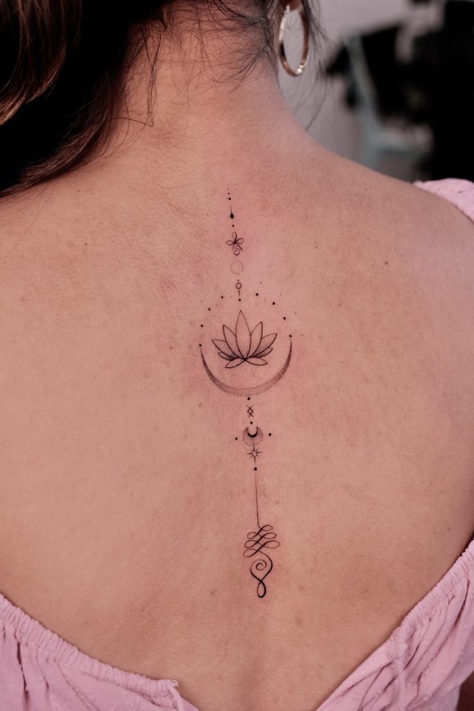 Lotus flower tattoo with a crescent moon centred on the upper back
