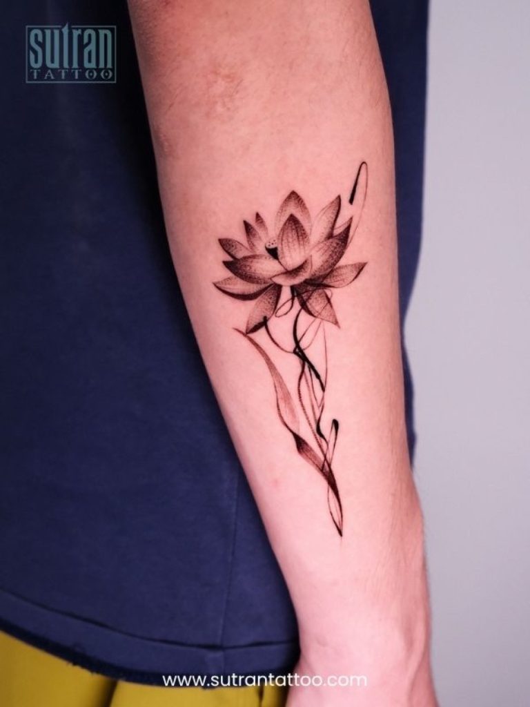 Fine-line red lotus flower tattoo on the forearm