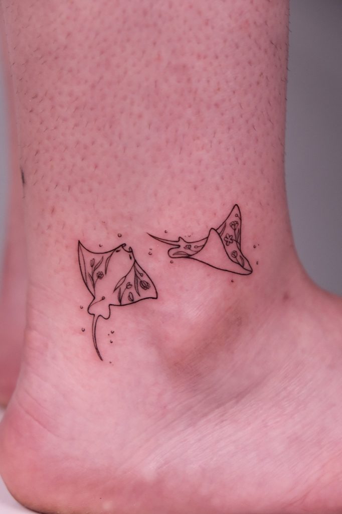 Fine-line manta ray tattoos on the ankle