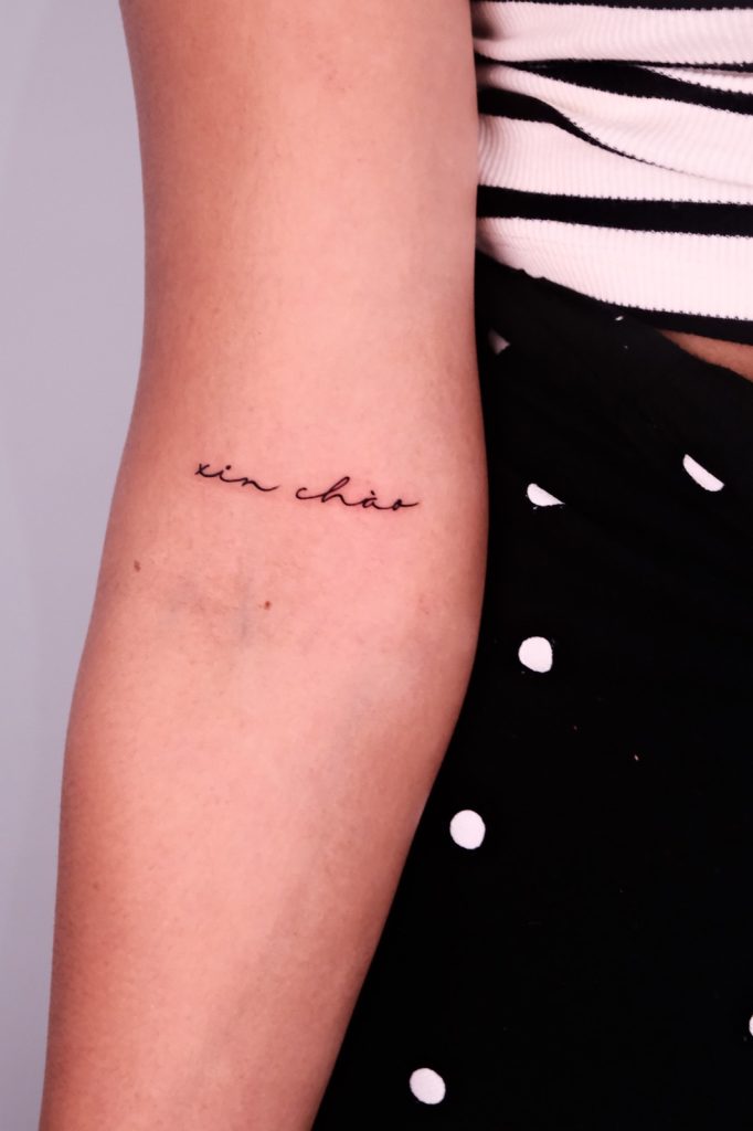Small fine-line script tattoo on the inner arm