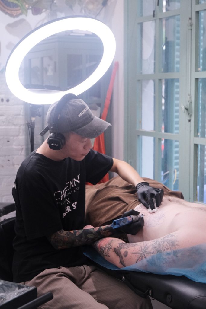 Tattoo artist working on a large tattoo during a long session