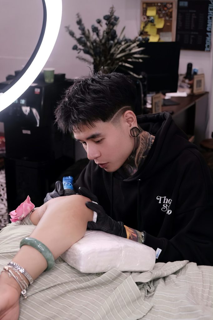 Client's forearm resting on a cushion during a tattoo session